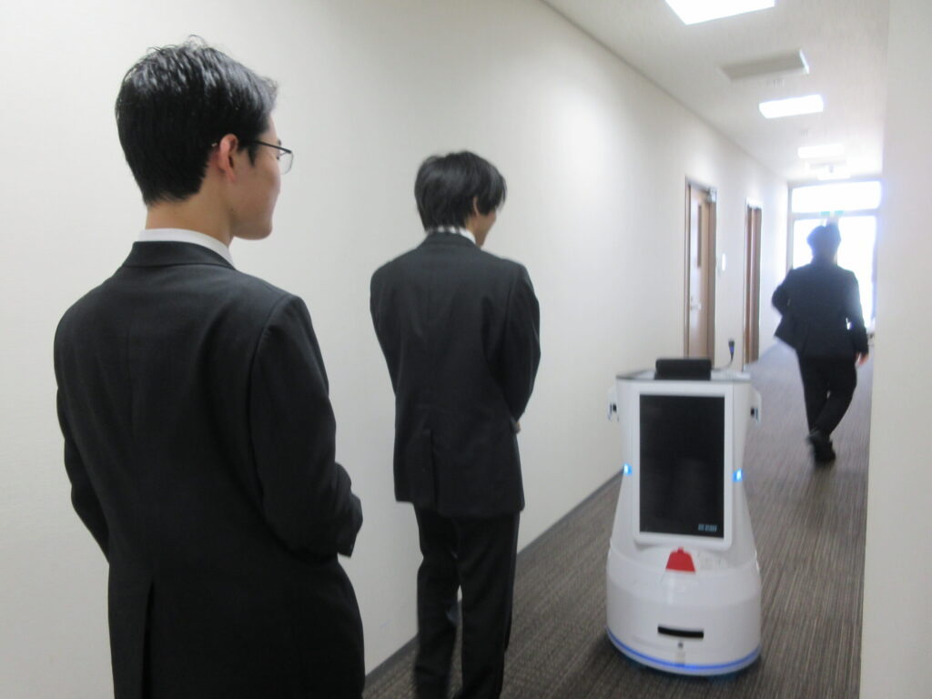 配膳ロボットが動く様子を見学している風景