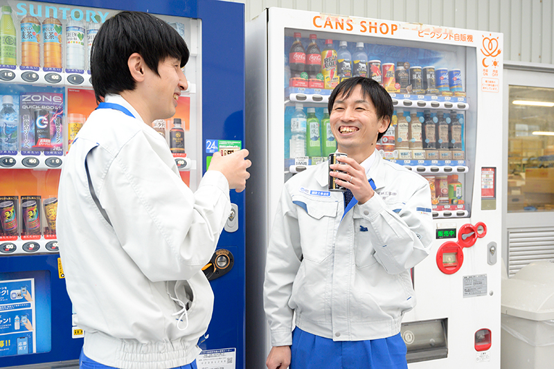 自動販売機の前で談笑する男性