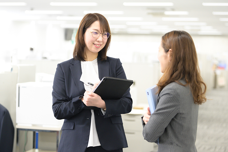 オフィスで立ち話をしている女性