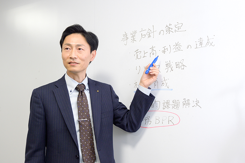ホワイトボードを指差す男性
